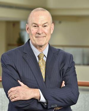 A portrait of Clay Marsh with his arms crossed